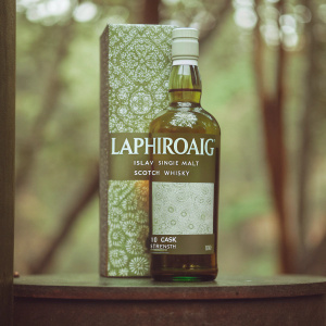 High-end spirits display: Laphroaig Islay Single Malt Scotch Whisky 10 Cask Strength. Elegant green bottle with intricate white label. Boxed in matching green and white design featuring 'Laphroaig' branding.