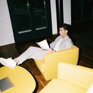 Cristiano Ronaldo in a casual meeting, sitting alone in a modern office space.