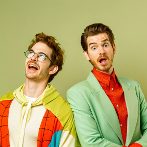 Andrew Garfield, two close-up shots. First image: tousled hair, second image: neat haircut. Both with solid green background.