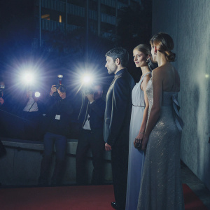 Aino Laberenz, Clemens Schick, and Veruschka von Lehndorff attend the 'Skyfall' premiere in Berlin. Wearing glamorous evening wear. Flashing lights from photographers