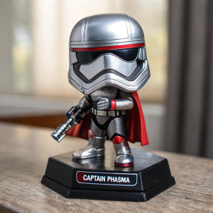 A Funko Pop-style figurine of Captain Phasma. Silver armor, red accents. Angular helmet, blaster in hand. Base reads 'Captain Phasma'