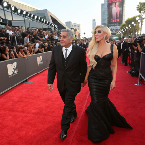 Joe Germanotta and Lady Gaga, walking together on a bustling red carpet. Crowds of fans and paparazzi in the background. Event: 2013 MTV Video Music Awards.