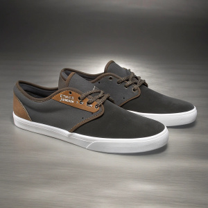 Etnies Jameson 2 Eco Low Top sneakers, black with brown highlights, clean lines. White sole, brown laces, on a minimalist gray background.