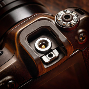A detailed shot of the Nikon D3100 DSLR camera. Focused on the central viewfinder and control dials.