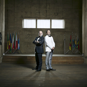 Gianni Infantino and Florentino Pérez at the FIFA gala dinner. Formal attire, colorful backdrop with flags, stage setting.