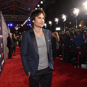 Ian Somerhalder at the iHeartRadio Music Awards. Stylish blazer, gray t-shirt. Formal event, carpeted floor, bright lights and cameras