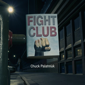 The book cover for Chuck Palahniuk's 'Fight Club' features a dynamic and bold design. A cartoon fist in combat stance stands out against a pastel backdrop. The title and author's name are rendered in powerful, graphic text.