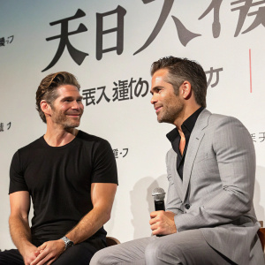 Eric Bana and Chris Pine in a casual meetup. Wearing black t-shirt and gray suit respectively. Japanese text backdrop