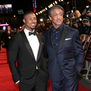 Michael B. Jordan and Sylvester Stallone at the premiere of Creed. Red carpet event with flashing cameras.