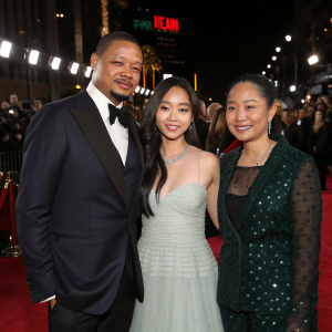 Terrence Howard, Mira Pak Howard, Qirin Love Howard, and Hero Howard, at an awards gala. Red carpet with crowd and Hollywood lights in background.