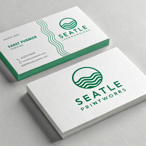 Modern business card design for Seattle Printworks. Clean and sleek look. White cards with green accents. Central logo featuring wave pattern. Flat surface with subtle shadow. Emphasizes branding and simple color scheme.