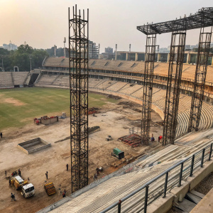 Feroz Shah Kotla Cricket Stadium renovation site, showing towering steel scaffolds and exposed concrete structures. Overhead view