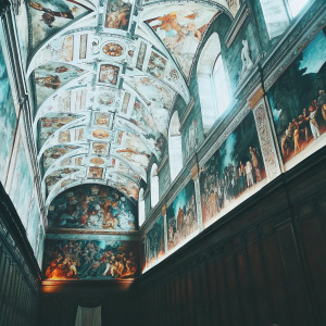 Stunning interior of the Sistine Chapel. Detailed frescoes cover the ceiling, depicting biblical scenes and intricate patterns. Warm lighting highlights the golden hues.