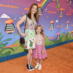 Alyson Hannigan and her daughter Keeva Jane Denisof at the Nickelodeon Kids' Choice Awards. Cartoon-themed backdrop with vibrant colors and whimsical designs.