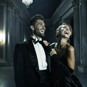 Olivier Giroud and Jennifer Giroud at a charity gala. Smiling broadly. Richly decorated ballroom setting.