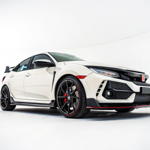 A close-up shot of the new Honda Civic Type R. Against a plain white background, the car's sleek lines and sporty design are vividly displayed.