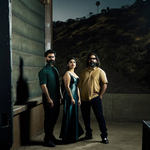 Aamir Khan, Zaira Wasim, and Advait Chandan posing in front of a grand Hollywood sign. Aamir Khan has a beard, Zaira Wasim is wearing makeup, Advait Chandan looks serious.