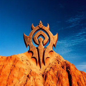 Intricate Orc Racial Crest inspired by World of Warcraft. The crest features a central circular motif surrounded by sharp, jagged shapes, set against a sleek black backdrop.