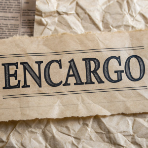 The word 'ENCARGO' displayed on a textured, crumpled paper background, in bold Spanish font.