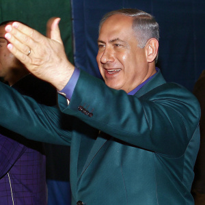 Close-up shot of Benjamin Netanyahu during a rally. Smiling and gesturing with both hands.