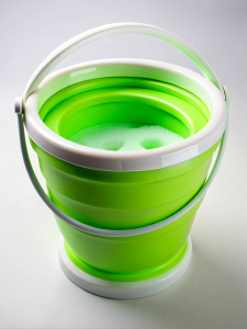 green round folding silicone bucket with white sides filled with foam water