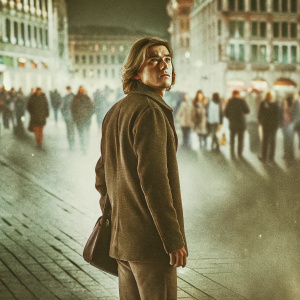 Emile Hirsch, an actor, standing in a busy urban square. His face filled with worry, staring intently ahead. The bustling cityscape behind him is blurred.