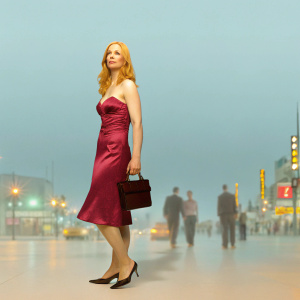 Deborah Ann Woll on a bustling Hollywood street. She's dressed in a dazzling magenta gown and black heels. Passing pedestrians and bright city lights