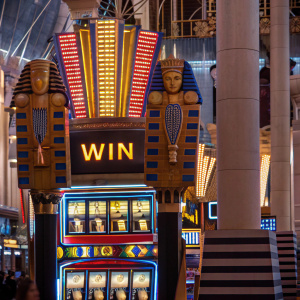 Pharaoh-themed slot machine in a Las Vegas casino. Hieroglyphics and golden symbols line the screen. The word 'Win' flashes prominently.
