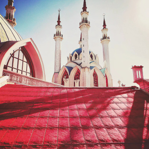 Qolşärif Mosque in Kazan Kremlin, Russia. The mosque features multiple slender minarets with intricate designs in blue and white hues. A sunny day with a clear blue sky.