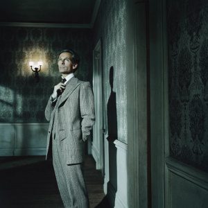 Peter Cushing, in vintage tweed suit, standing in eerie, dimly lit room. Dark wallpaper with intricate patterns. Antique lamp casting shadows.