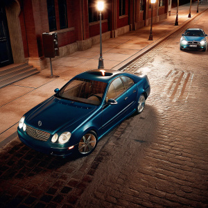 3D rendered image of a sleek, dark blue Mercedes-Benz CLK 500 on a deserted street at night. A police car is parked a few meters away. Ambient lights from street lamps casting shadows.