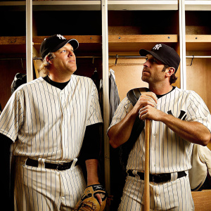 Curt Schilling and Jason Varitek, both in Yankees caps, standing in the locker room after a game.