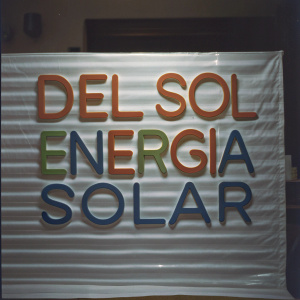 Close-up of a sleek, modern logo for Del Sol Energia Solar. The design features bold, vibrant typography in shades of orange, blue, and green. The logo stands out against a textured, off-white backdrop, creating a striking visual contrast.
