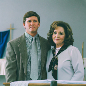Michael Flynn, in somber attire, and K.T. McFarland pose for a formal photo. Blue backdrop