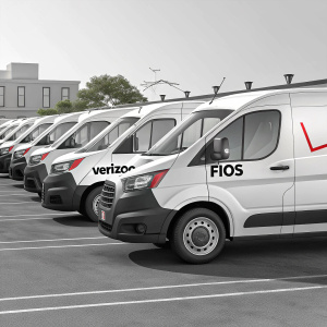 High-resolution image: A lineup of white Verizon Fios vans parked neatly in a lot. Fios logo and promotional text visible on each vehicle.