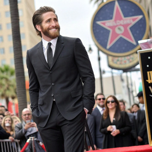 Jake Gyllenhaal, bearded actor, in a stylish black suit. At Hollywood Walk of Fame unveiling ceremony.
