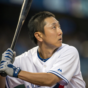 Munenori Kawasaki, intense focus, poised for action. Wearing a white jersey with blue accents. Blurred stadium background.