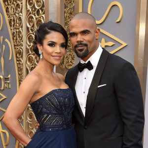 Shemar Moore and Anabelle Acosta, at a glamorous gala. The backdrop features intricate gold designs. Both are dressed formally, posing elegantly for the cameras.