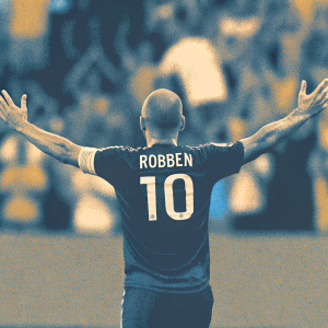Arjen Robben, sporting a cropped-back hairstyle, in a dark blue jersey emblazoned with his name 'ROBBEN' and the number '10'. He poses in a triumphant celebration with arms outstretched. The background is a blur of enthusiastic spectators at a vibrant soccer stadium.