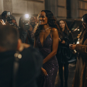 Selita Ebanks at the annual Glamour Awards, stunning in a deep purple sequined gown. Crowded backdrop of flashing cameras and celebrities.