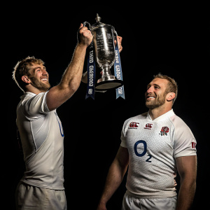 Chris Robshaw and Kelly Brown, rugby stars, holding up the trophy. Dark studio setting, black background