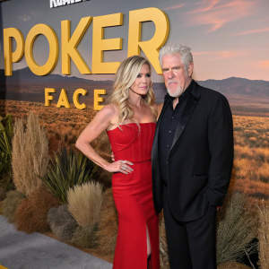 Allison Dunbar and Ron Perlman at the 'Poker Face' film premiere. They are dressed in formal attire, standing in front of a vibrant desert-themed backdrop.