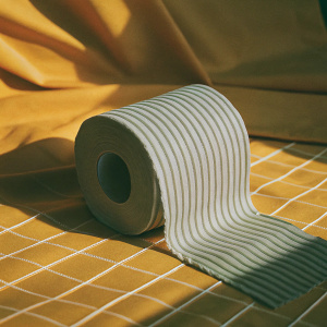 Photorealistic image of a white toilet paper roll. Ribbed texture, dramatic side lighting, maroon background