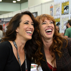 Unposed shot of Maggie Wheeler and Tanna Frederick backstage at Comic-Con, both laughing.