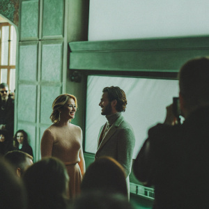 Jennifer Morrison and Colin O'Donoghue at the Sundance Film Festival. Both are dressed in formal wear. Jennifer in a peach dress, Colin in a gray turtleneck. Crowds and photographers in the background.