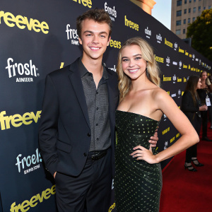 Eamonn Welliver and Cora Welliver at a movie premiere event for Amazon Freevee's 'Bosch Legacy'. The backdrop features Freevee logos and a bustling crowd in the background.