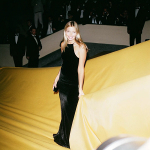 Maria Sharapova at a glamorous gala event. Dressed in a shimmering black evening gown. Crowd in the background