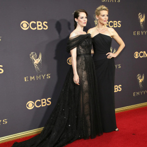 Claire Foy and Vanessa Kirby at the Emmy Awards. Black and off-the-shoulder gown. Formal event. Red carpet. Dark backdrop with CBS and Emmy logos.