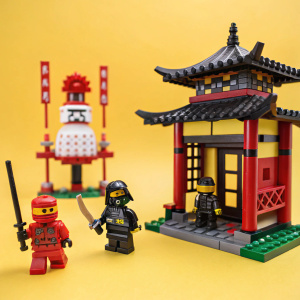 Photograph of LEGO Ninjago toy set. Bright yellow background, highlighting intricate design and dynamic action figures.