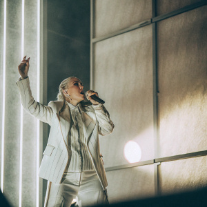 Christina Aguilera, the pop diva, performing on stage. Dramatic lighting and a purple backdrop.